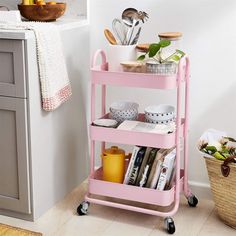 a pink cart filled with lots of kitchen items