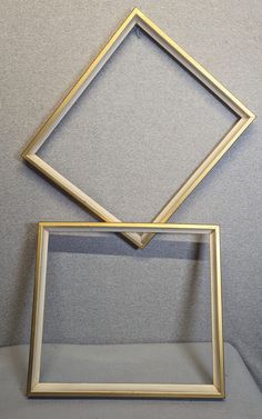 two gold frames sitting on top of each other