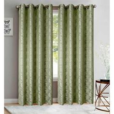 the curtains in this room are green and white with an intricate pattern on them,