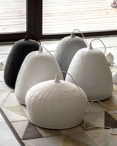 four white pumpkins sitting on top of a rug