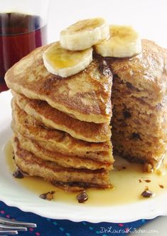 a stack of pancakes with bananas and syrup