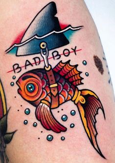 a tattoo with a fish under an umbrella on it's arm and the words bad boy above it