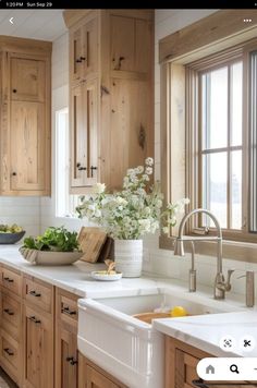 a kitchen filled with lots of wooden cabinets and white counter top space next to a window