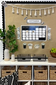 a table topped with baskets filled with fruit and veggies next to a wall calendar