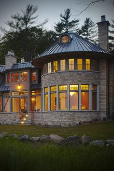 a large house with lots of windows and lights on it's front lawn area