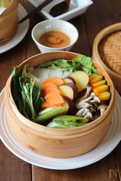 a wooden bowl filled with vegetables on top of a white plate