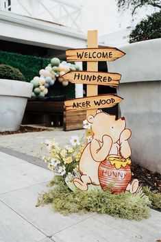 a winnie the pooh wooden sign with flowers