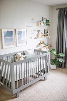 a baby's room with a white crib and gray curtains