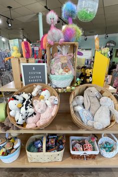 two baskets filled with stuffed animals sitting on top of a wooden shelf in a store