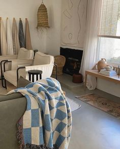 a living room filled with furniture and blankets on top of it's sofas