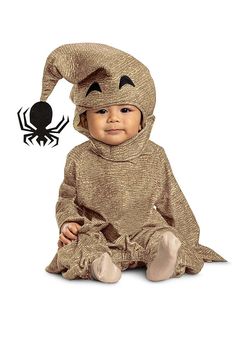 a baby dressed in a costume sitting on the ground with a spider logo above it