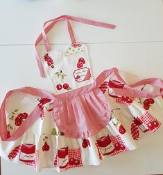 a red and white apron with cherries on it