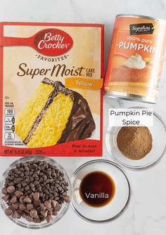 ingredients to make pumpkin pie on a white marble counter top, including cake mix and pudding