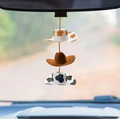 a car dashboard with a hat hanging from it's side window and other items attached to the dash board