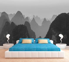 a bedroom with mountains in the background and blue bedspread on the bottom bed