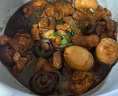 a white bowl filled with meat and mushrooms