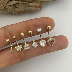 a person's finger with five different piercings on it and one is gold