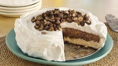 there is a cake with white frosting and chocolate chips on the top, sitting on a plate