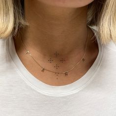 a woman wearing a gold necklace with stars on it