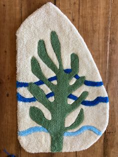 a towel with a tree on it sitting on a wooden floor in front of a wall