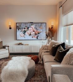 a living room filled with furniture and a flat screen tv mounted to the side of a wall