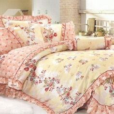 the comforter is made up with pink flowers and ruffled trims on it