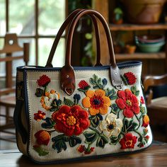 a handbag with flowers on it sitting on a table