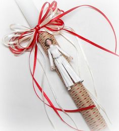 an ornament is wrapped in red and white ribbon