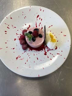 a white plate topped with fruit and whipped cream covered in red blood splatters