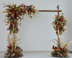 an arch decorated with flowers and feathers is shown in this image, it appears to be made out of wood