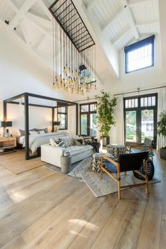 a living room filled with furniture and a chandelier hanging from the skylight