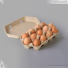 an egg carton filled with brown eggs sitting on top of a table next to a cardboard tray