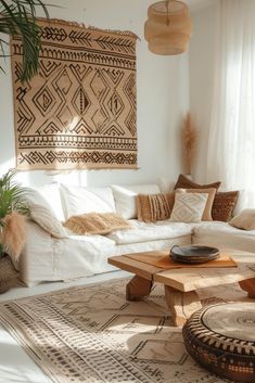 a living room with white couches and rugs in front of a wall hanging