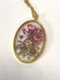 Goldtone oval bezel pendant filled with resin & pink and white flowers. Chain is also goldtone and is about 16" long. Weight and size are estimated. Pink And White Flowers, Bezel Pendant, Flower Pendant Necklace, Flower Pendant, Resin Jewelry, Pendant Necklaces, White Flowers, Favorite Jewelry, Pink White