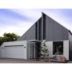 a house with a car parked in front of it and two garages on the other side