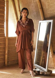 Crafted out of modal fabric, this dress incorporates honeycomb smocking delicately tucked in a chic kaftan silhouette. This is paired with straight pants and comes as a set of 2. Fabric : Modal Satin Colour : Brown Embroidery details : Hand embroidery No.of components : 2 Delivery time : 15-20 days Washing Instructions : DRY CLEAN ONLY Honeycomb Smocking, Kaftan Sleeves, V Neck Kaftan, Embroidered Kaftan, Simple Pakistani Dresses, Designer Dresses Casual, Cycling Fashion, Satin Color, Indian Fashion Dresses