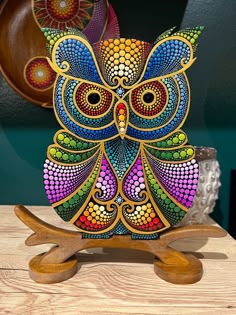 an owl made out of wood sitting on top of a wooden table