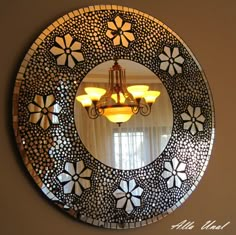 a round mirror hanging on the wall above a chandelier