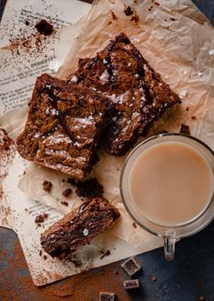 some brownies and a cup of coffee on a piece of paper with chocolate chunks