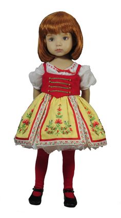 a doll with red hair wearing a yellow dress and black shoes, standing in front of a white background