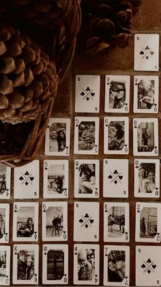 playing cards are laid out on the floor next to a basket with pine cones in it