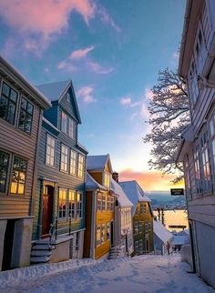 the sun is setting over some houses in winter