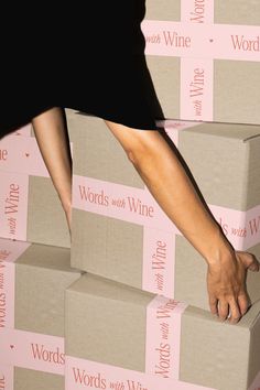 a woman reaching for a box with her hand on it that is stacked high in the air