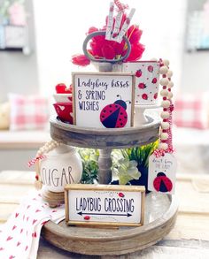 three tiered display with ladybug signs and flowers