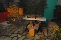 an outdoor dining area is lit up at night with candles and plates on the table