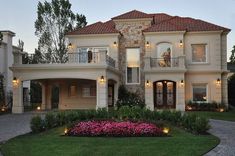 a large house with lots of windows and lights on it's front lawn area