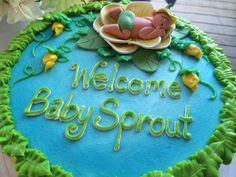 a welcome baby sprout cake is decorated with fondant and icing flowers