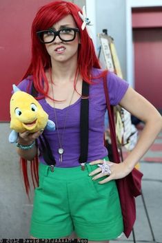 a woman with red hair and glasses holding a stuffed animal