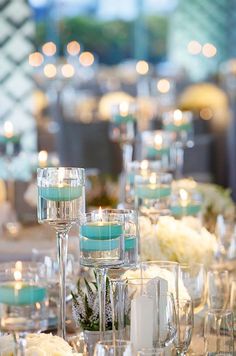 the table is set with candles, flowers and wine glasses for an elegant wedding reception