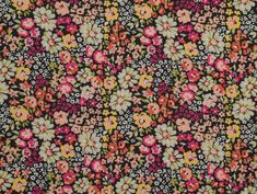 an old flowery fabric with many different colors and sizes on it's surface